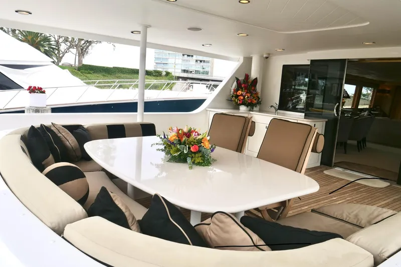 Slide: The Image of Luxurious Westport 112 yacht deck with elegant seating and floral centerpiece, year 2000 model. - 76