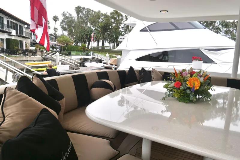 Slide: The Image of Luxurious Westport 112 yacht interior with elegant seating and floral centerpiece, docked at marina. - 77
