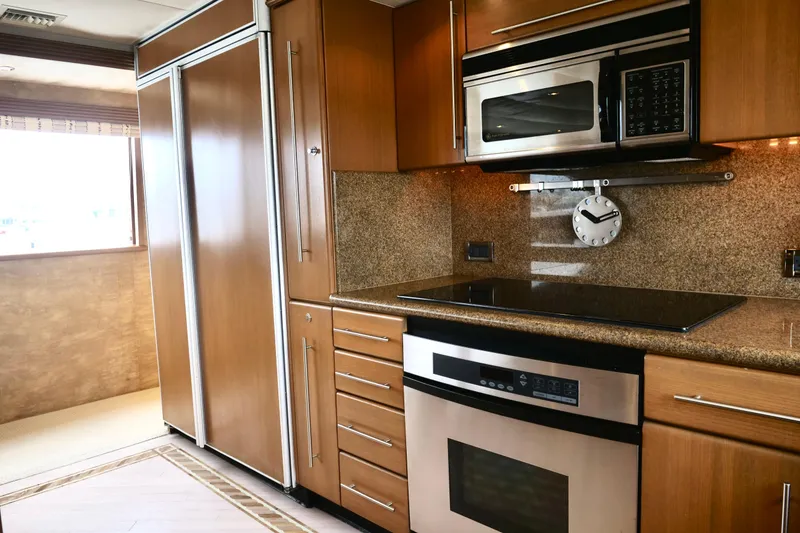 Slide: The Image of Modern kitchen interior on 2000 Westport 112 yacht with wood cabinetry and stainless steel appliances. - 82