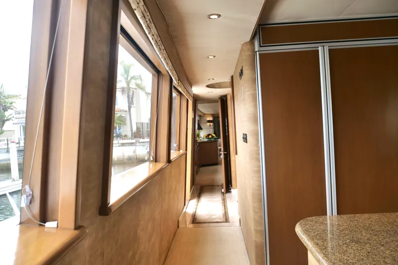 Slide: The Image of Luxurious interior hallway of 2000 Westport 112 yacht with wood paneling and large windows. - 83