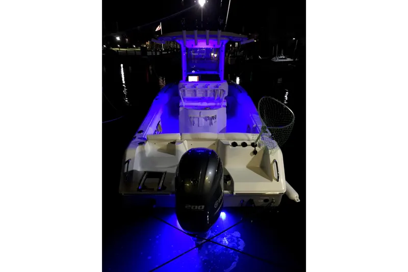 Slide: The Image of 2017 Sea Hunt Ultra 235 SE boat illuminated with blue lights at night. - 11