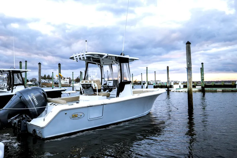 Slide: The Image of 2017 Sea Hunt Ultra 235 SE boat docked in a marina at sunset. - 12