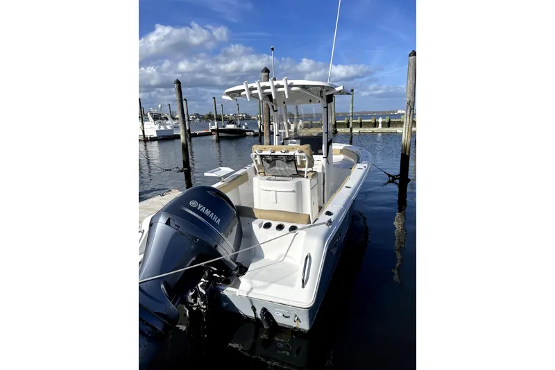 Slide: The Image of 2017 Sea Hunt Ultra 235 SE boat docked with Yamaha engine, under clear blue sky. - 3