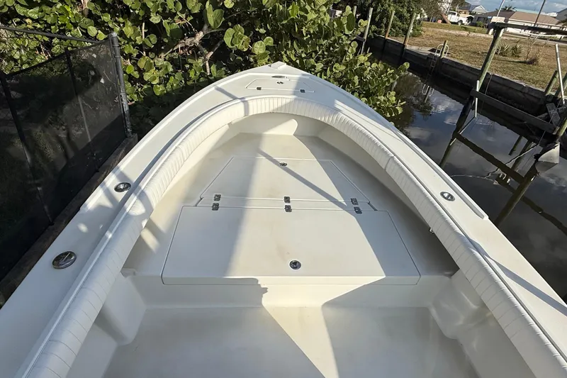 Slide: The Image of 2016 Dorado 23 boat with spacious deck, docked near lush greenery. - 14
