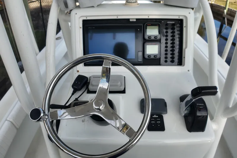 Slide: The Image of 2016 Dorado 23 boat dashboard with steering wheel and navigation controls. - 18