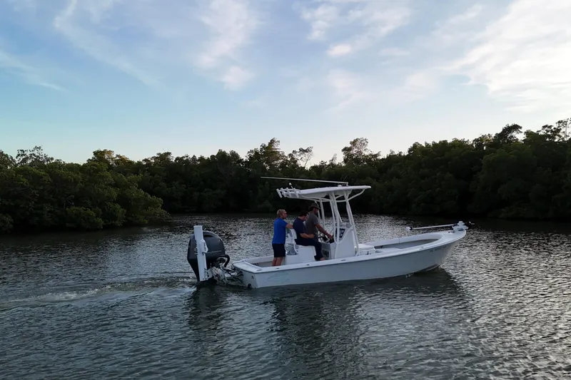 Slide: The Image of 2016 Dorado 23 boat cruising on a calm river with lush greenery. - 22