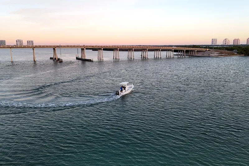 Slide: The Image of 2016 Dorado 23 boat cruising near a bridge at sunset. - 44