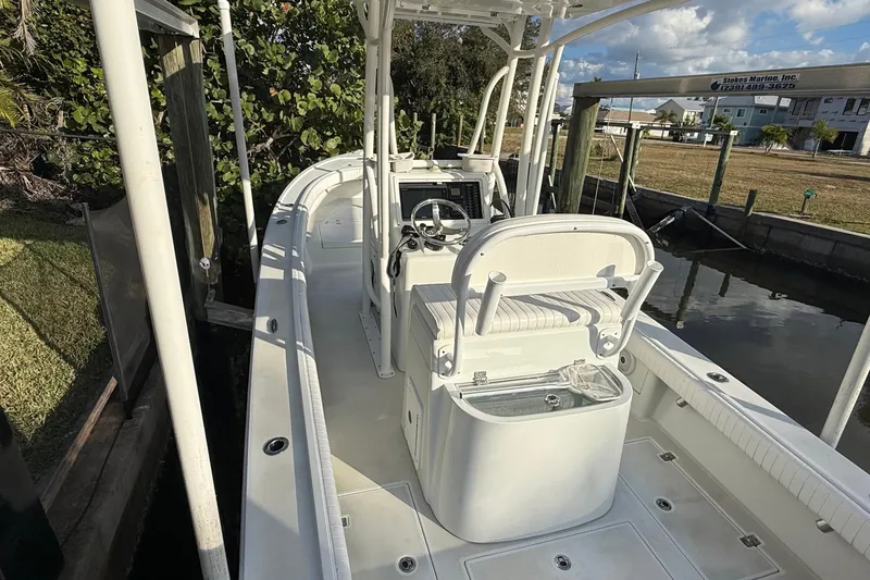 Slide: The Image of 2016 Dorado 23 boat with steering console, docked near lush greenery. - 8
