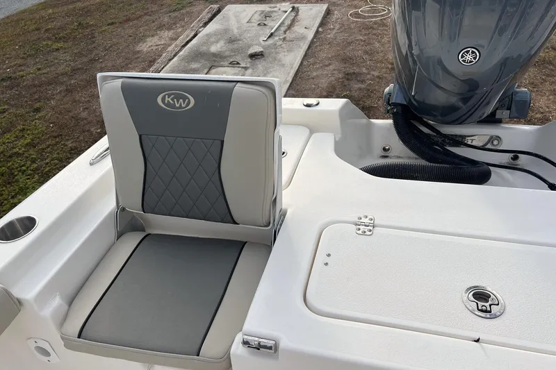 Slide: The Image of 2026 Key West 230 Bay Reef boat seat and motor detail, featuring gray upholstery. - 11
