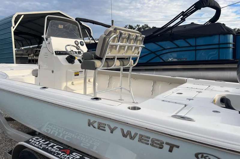 Slide: The Image of 2026 Key West 230 Bay Reef boat with console and seating, parked outdoors. - 4