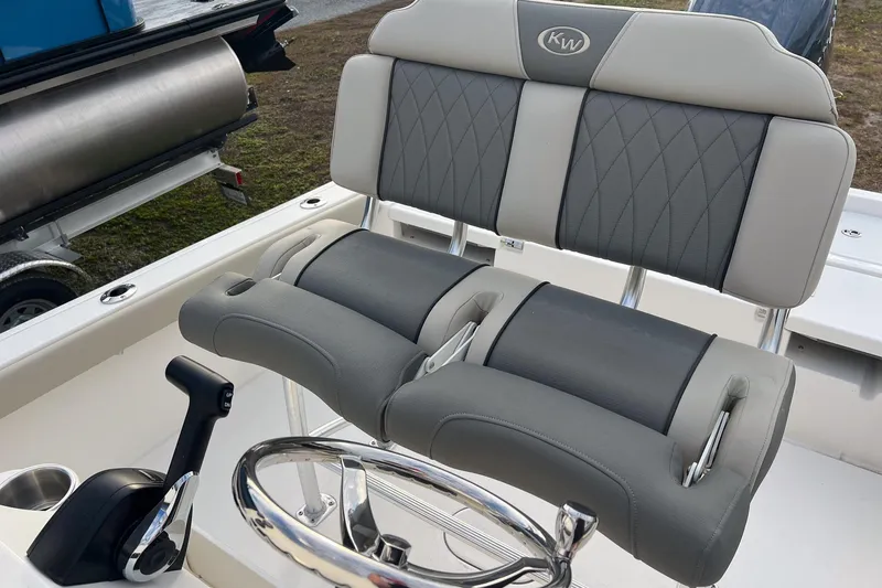 Slide: The Image of 2026 Key West 230 Bay Reef boat interior with cushioned seating and steering wheel. - 7