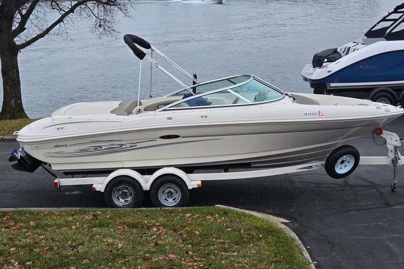 The Image of 2004 Sea Ray 200 Sport boat on trailer by a lake. - 0