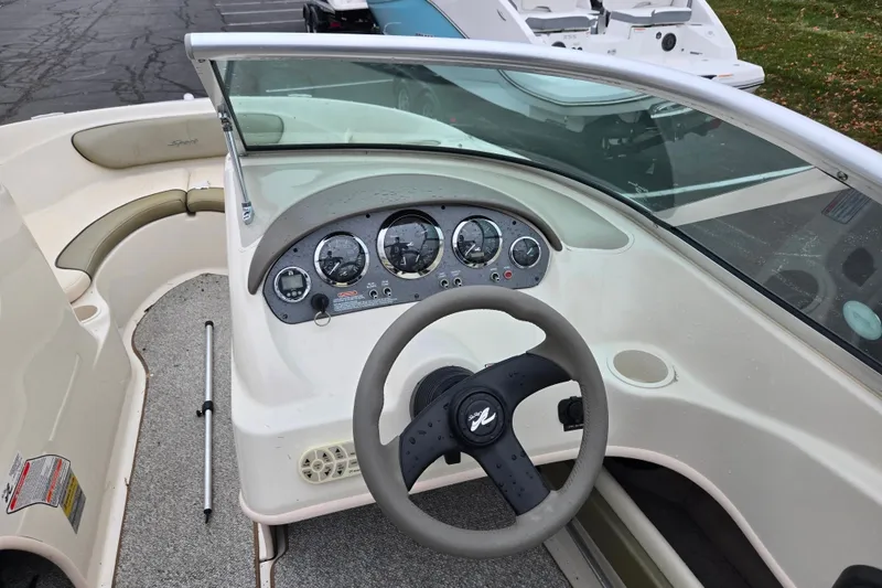 Slide: The Image of 2004 Sea Ray 200 Sport boat dashboard with steering wheel and gauges. - 13