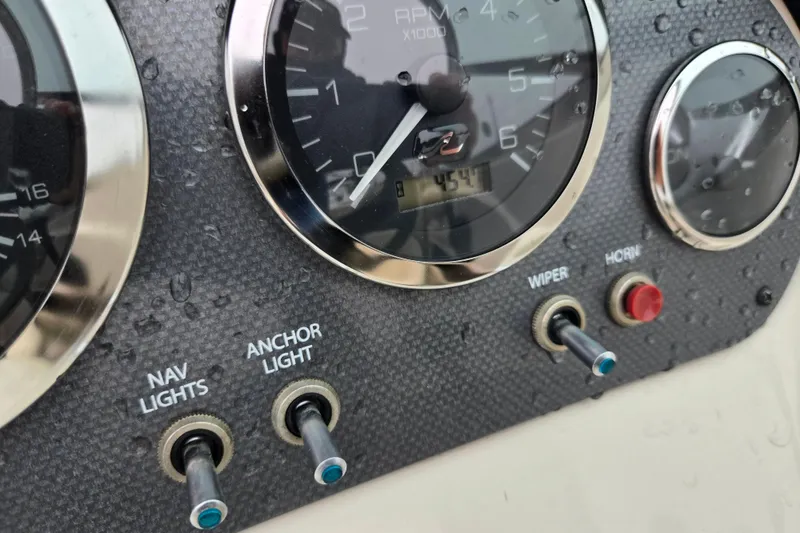 Slide: The Image of Dashboard of a 2004 Sea Ray 200 Sport boat with gauges and switches. - 14
