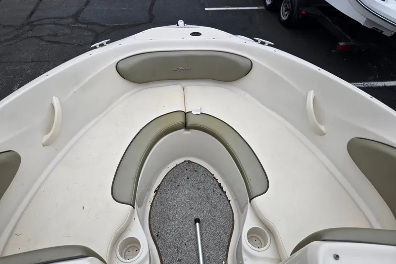Slide: The Image of 2004 Sea Ray 200 Sport boat interior with cushioned seating and cup holders. - 17