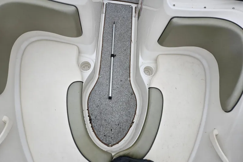 Slide: The Image of Interior of a 2004 Sea Ray 200 Sport boat, featuring seating and carpeted flooring. - 19