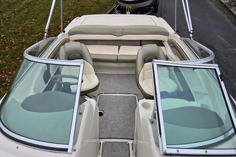 Slide: The Image of 2004 Sea Ray 200 Sport boat interior with seating and steering wheel. - 20