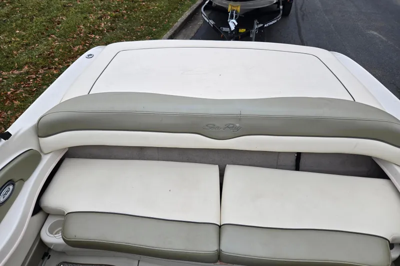 Slide: The Image of 2004 Sea Ray 200 Sport boat interior with cushioned seating and logo detail. - 22