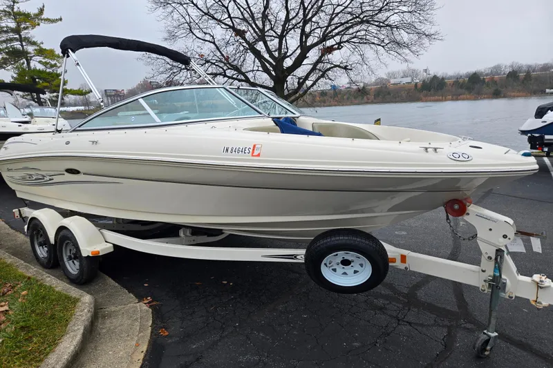 Slide: The Image of 2004 Sea Ray 200 Sport boat on trailer by a lakeside, overcast day. - 8