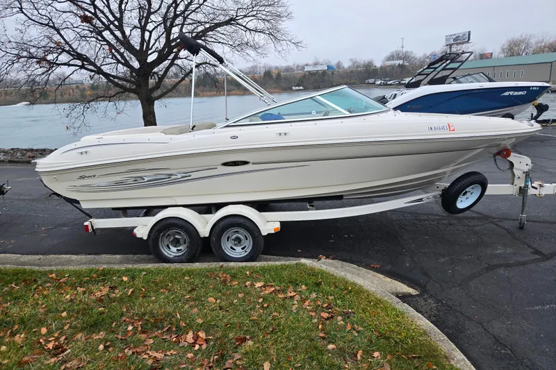Slide: The Image of 2004 Sea Ray 200 Sport boat on trailer by riverside, overcast day. - 9