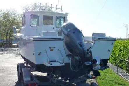 Slide: The Image of 2016 Parker 2120 Sport Cabin boat on trailer, front view, overcast sky. - 10
