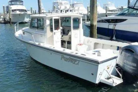 Slide: The Image of 2016 Parker 2120 Sport Cabin boat docked in marina, surrounded by other vessels. - 7