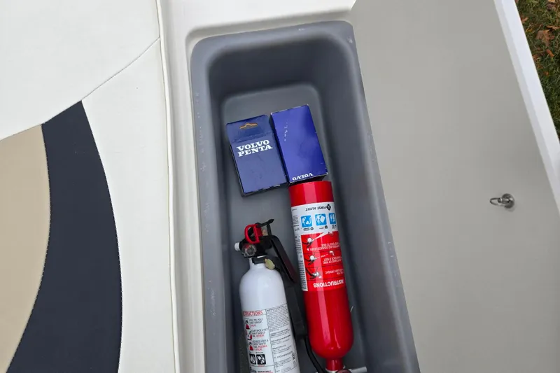 Slide: The Image of Storage compartment in a 2016 Stingray 198 RX boat with fire extinguishers and Volvo Penta parts. - 11