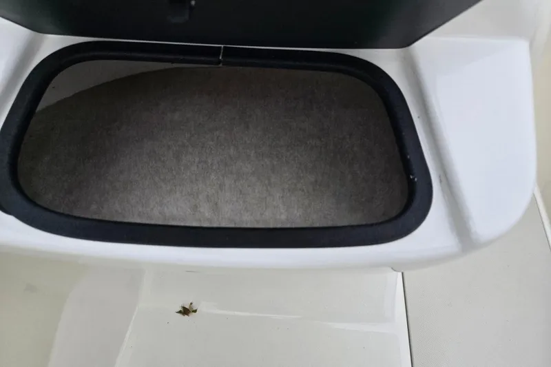 Slide: The Image of 2016 Stingray 198 RX boat storage compartment with open lid. - 13
