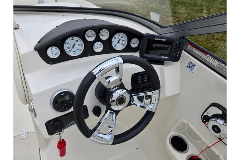 Slide: The Image of 2016 Stingray 198 RX boat dashboard with steering wheel and gauges. - 16