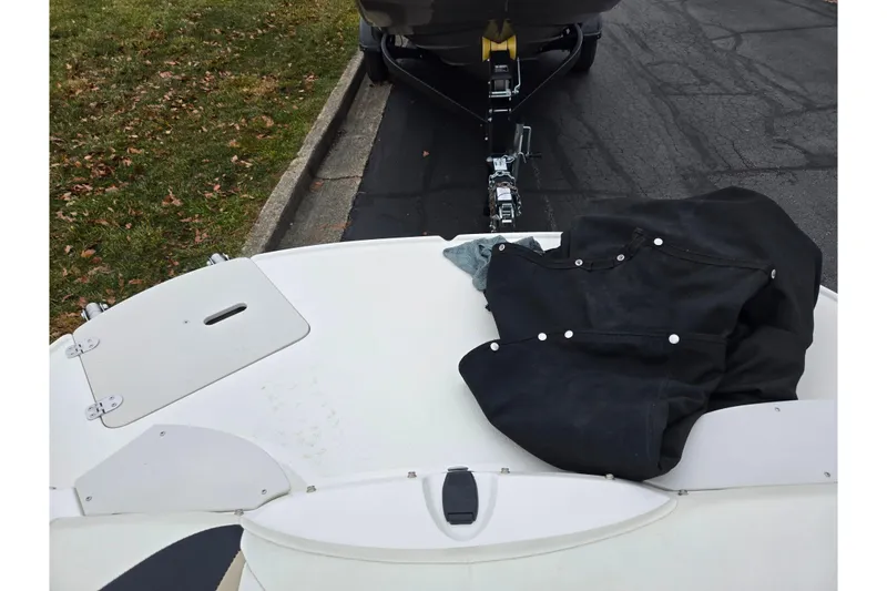 Slide: The Image of 2016 Stingray 198 RX boat on trailer with black cover, parked on asphalt. - 25