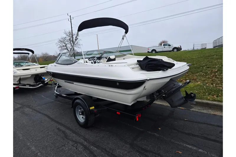 Slide: The Image of 2016 Stingray 198 RX boat on trailer, parked outdoors on a cloudy day. - 3