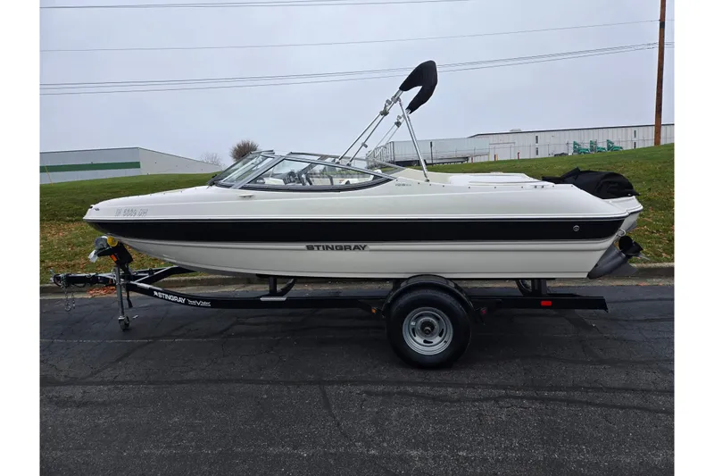 Slide: The Image of 2016 Stingray 198 RX boat on trailer, side view, parked outdoors. - 4