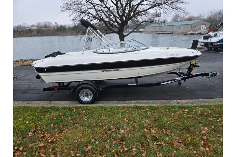 Slide: The Image of 2016 Stingray 198 RX boat on trailer by a lakeside in autumn setting. - 9