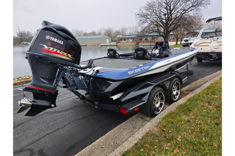 Slide: The Image of 2021 Skeeter FXR20 boat with Yamaha VMAX engine, parked near a lake. - 1