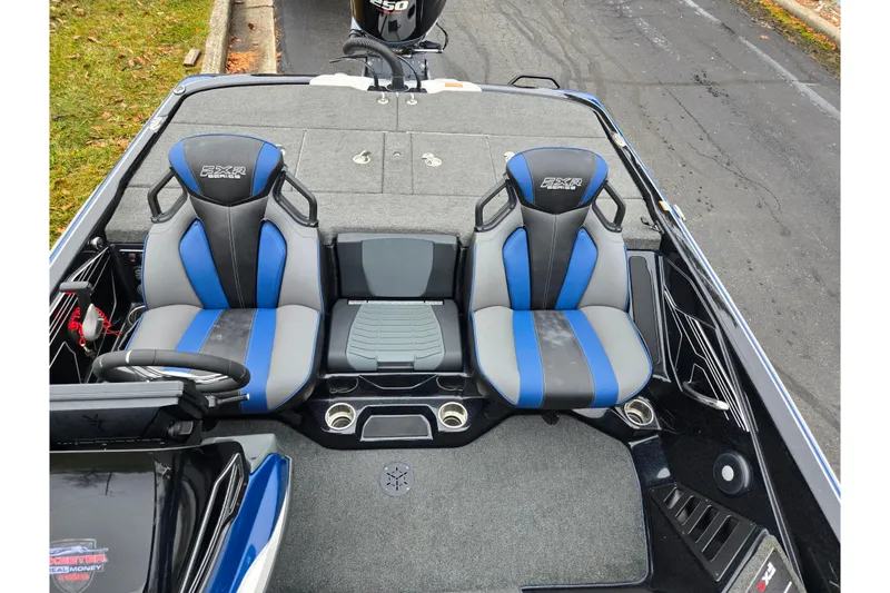 Slide: The Image of 2021 Skeeter FXR20 boat interior with blue and gray seats, steering wheel, and storage compartments. - 12