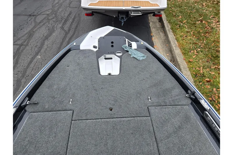 Slide: The Image of 2021 Skeeter FXR20 boat deck with gray carpeting, parked on a street. - 25