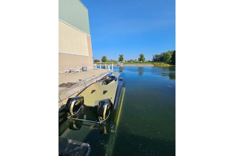 Slide: The Image of 2002 MTI 40RP powerboat docked by a calm waterfront under clear blue skies. - 42