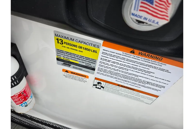 Slide: The Image of Scarab 255 ID 2021 boat capacity warning labels, maximum 13 persons or 1850 lbs, made in USA. - 13