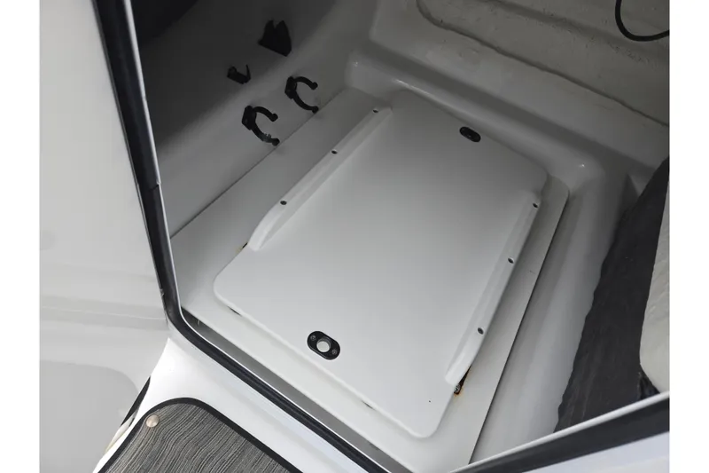 Slide: The Image of 2021 Scarab 255 ID boat storage compartment with secure hatch and interior details. - 19
