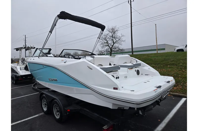 Slide: The Image of 2021 Scarab 255 ID boat on trailer, white and blue, parked outdoors. - 3
