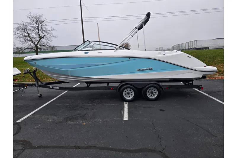 Slide: The Image of 2021 Scarab 255 ID boat on trailer, blue and white design, parked outdoors. - 4