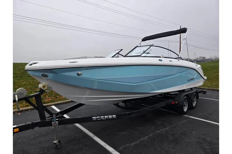 Slide: The Image of 2021 Scarab 255 ID boat on trailer, blue and white design, parked outdoors. - 5