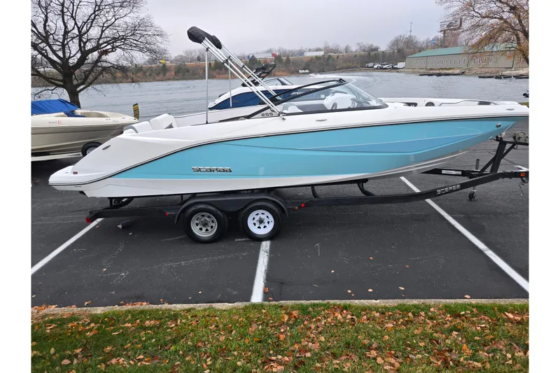Slide: The Image of 2021 Scarab 255 ID boat on trailer, parked near a lake, showcasing sleek design. - 9