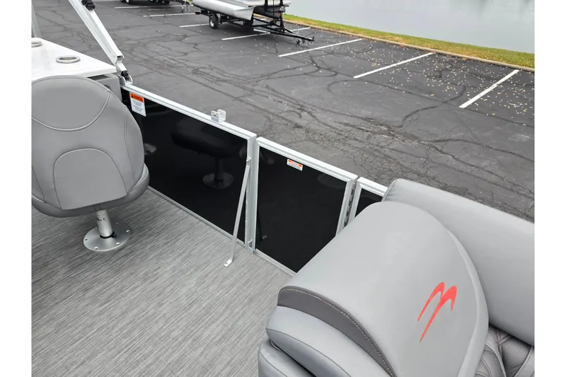 Slide: The Image of 2022 Bennington LX 24 Swingback boat interior with gray seating and lake view. - 12