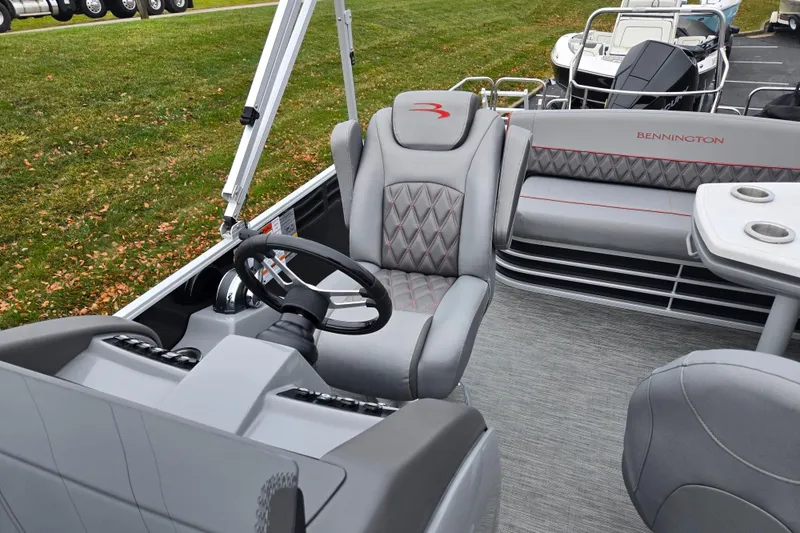 Slide: The Image of 2022 Bennington LX 24 Swingback interior with gray seating and steering wheel. - 13
