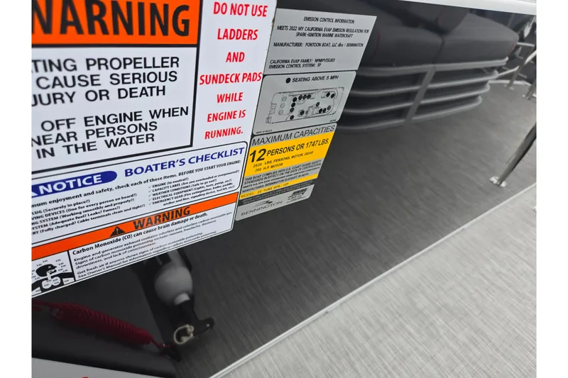 Slide: The Image of Warning labels on 2022 Bennington LX 24 Swingback boat, highlighting safety and capacity information. - 15