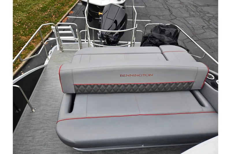 Slide: The Image of 2022 Bennington LX 24 Swingback boat with gray seating and red accents. - 16