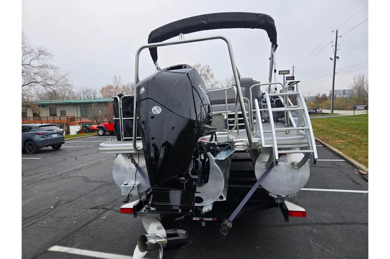Slide: The Image of 2022 Bennington LX 24 Swingback pontoon boat with outboard motor in parking lot. - 2