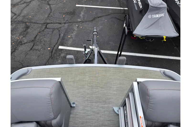 Slide: The Image of 2022 Bennington LX 24 Swingback boat interior with gray seating and trailer view. - 26