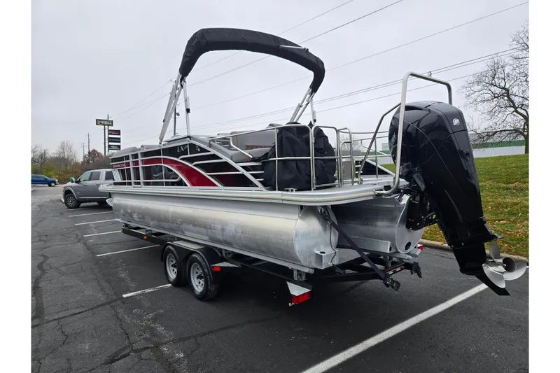 Slide: The Image of 2022 Bennington LX 24 Swingback pontoon boat on trailer in parking lot. - 3